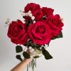 Mujer sujetando el ramo eternity de rosas rojas de terciopelo con paniculata