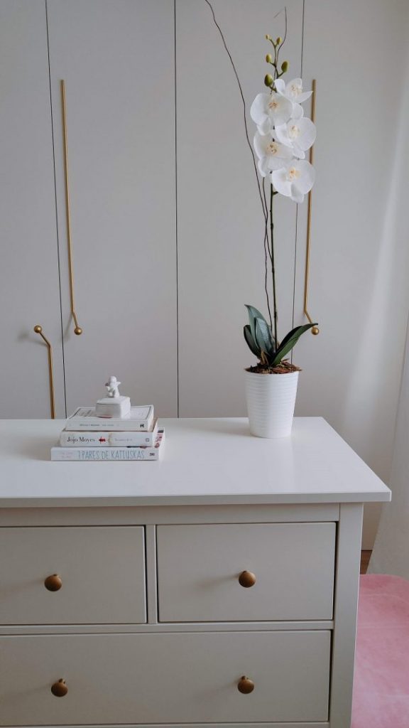 Orquídea Artificial en tonos blanco y rosado colocada en una maceta blanca.