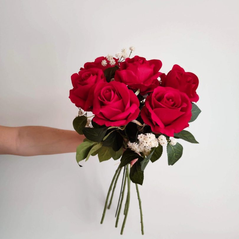 Mujer sujetando el ramo eternity de rosas rojas de terciopelo con paniculata